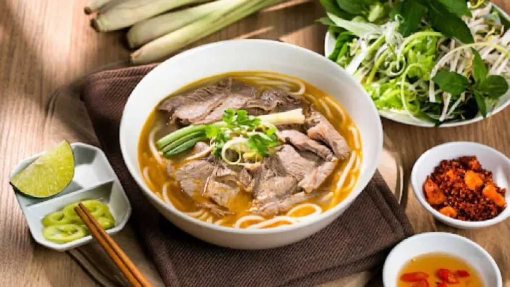 Tô bún bò Huế chuẩn vị với nước dùng đậm đà, cay nhẹ và hương thơm đặc trưng từ mắm ruốc.